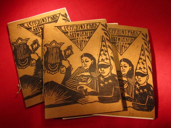 es una xilografia sobre papel madera, muestra 5 personajes alrededor de una mesa de la que emana una luz, en un triangulo se lee el titulo del libro