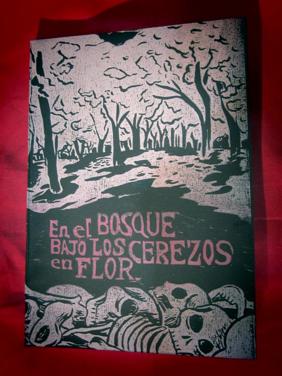 Es una xilografia de tinta blanca y rosa sobre papel negro. En rosa dice: 