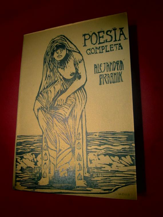 Es una xilografia tinta negra sobre papel dorado, dice Poesia completa, Alejandra pizarnik, y en la ilustración vemos una persona sentada en una silla de espaldas al mar con un libro en su regazo